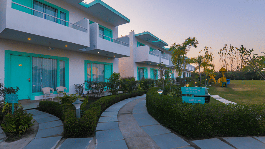 Exterior view of buildings and landscaped grounds at Vedikant Resorts The Mallard Corbett at dusk.
