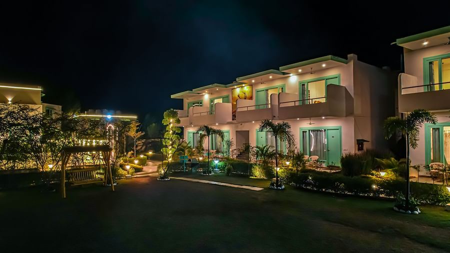 The entrance porch of Vedikant Resorts The Mallard Corbett with seating arrangements, potted plants, a chandelier, and visible main doors.