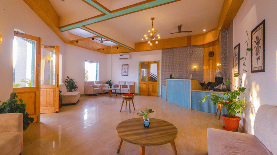 A spacious living area at Vedikant Resorts The Mallard Corbett features comfortable seating, a dining table, and ample light.