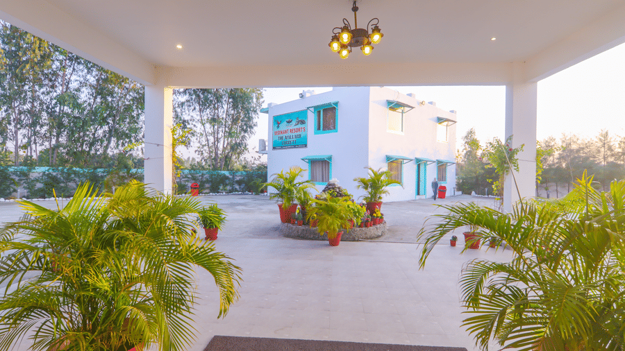 An outdoor covered area at Vedikant Resorts The Mallard Corbett features plants and an entrance to the building.