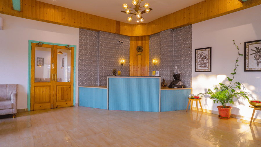 The reception area at Vedikant Resorts The Mallard Corbett has a blue counter and a bright, welcoming space.
