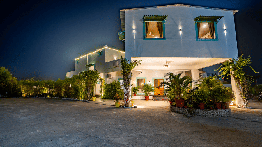 Facade of Vedikant Resorts The Mallarrd Corbett featuring a huge concrete lawn and the entrance of the resort which is decorated by plants and flower pots.