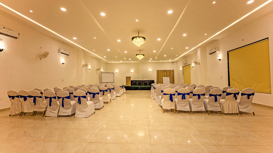 Mystic Jungle Banquet hall at Vedikant Resorts The Mallard Corbett featuring chairs, fans, AC, chandeliers, and a podium.
