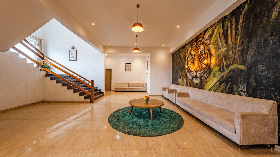 Reception lobby at Vedikant Resorts The Mallard Corbett featuring sofa and a centre table, and a flight of stairs leading to other floor.