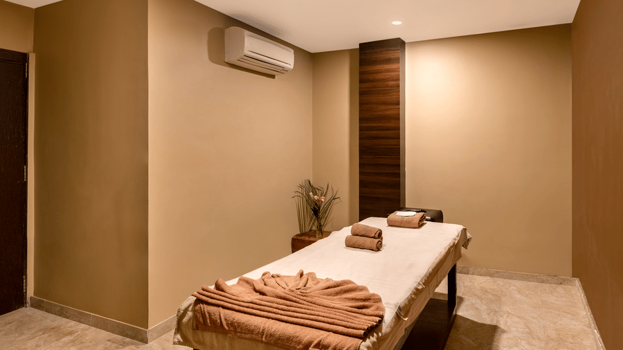 A massage room with a table, towels, and a small flower arrangement at our Kumbhalgarh spa.