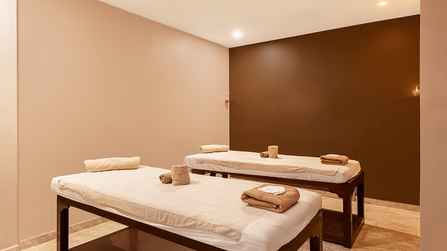A spa room with two massage tables, towels, and a warm, inviting atmosphere - Via Lakhela Resort & Spa, Kumbhalgarh