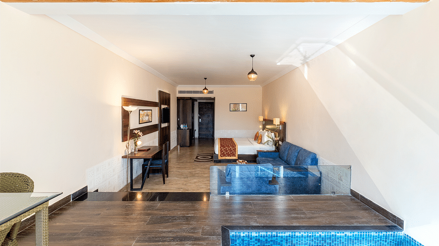 A hallway with a door leading to a room with small plunge pool - Via Lakhela Resort & Spa