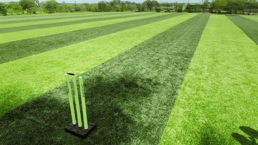 A close-up view of a green synthetic turf field with green cricket stumps placed on the ground | Vintage Trails By Ilara