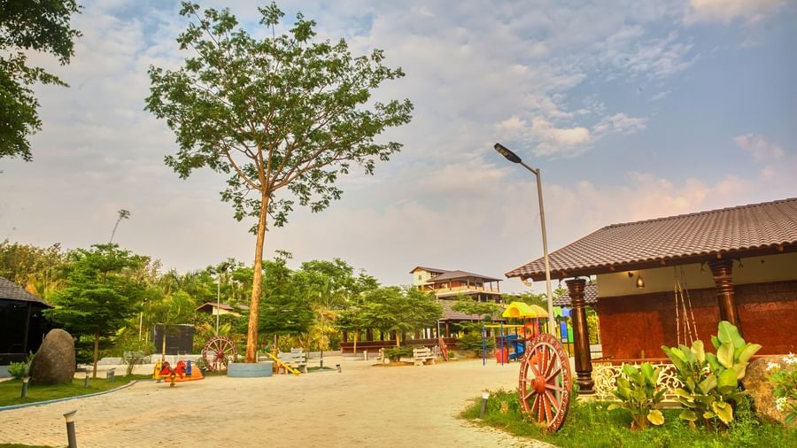 A paved outdoor area with a decorative street lamp and green landscaping, leading towards a modern building under a bright sky. - Vintage Trails by Ilara