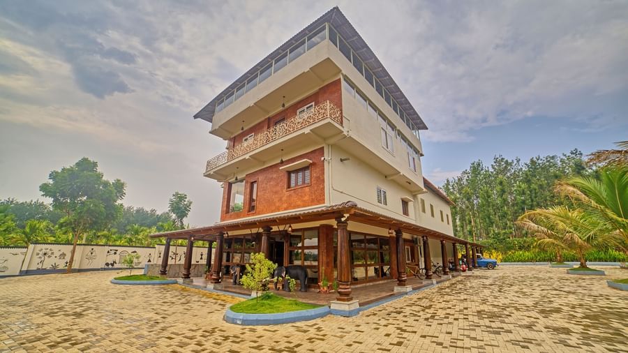 A multi-level building with a modern design, featuring wooden cladding surrounded by green landscaping and - Vintage Trails by Ilara