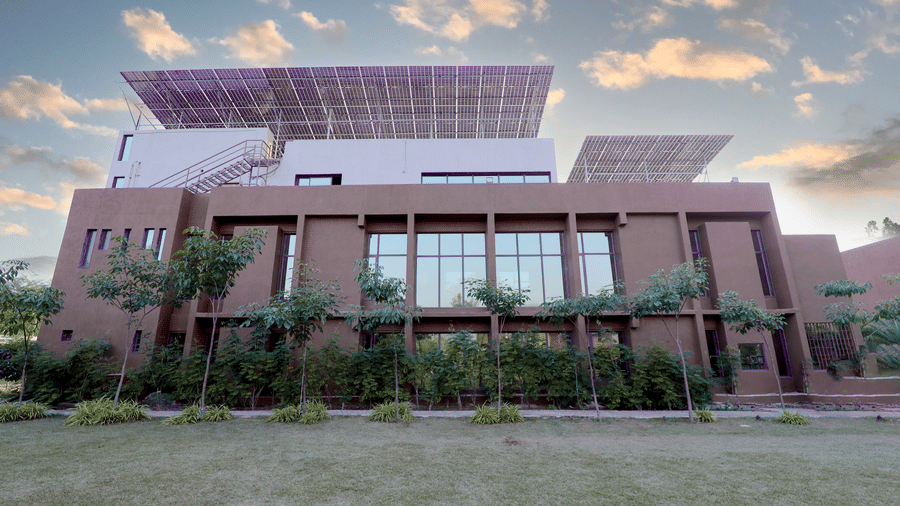 The striking modern facade of the main building at Vinti Resort, Ambaji is topped with extensive, eco-friendly solar panels.