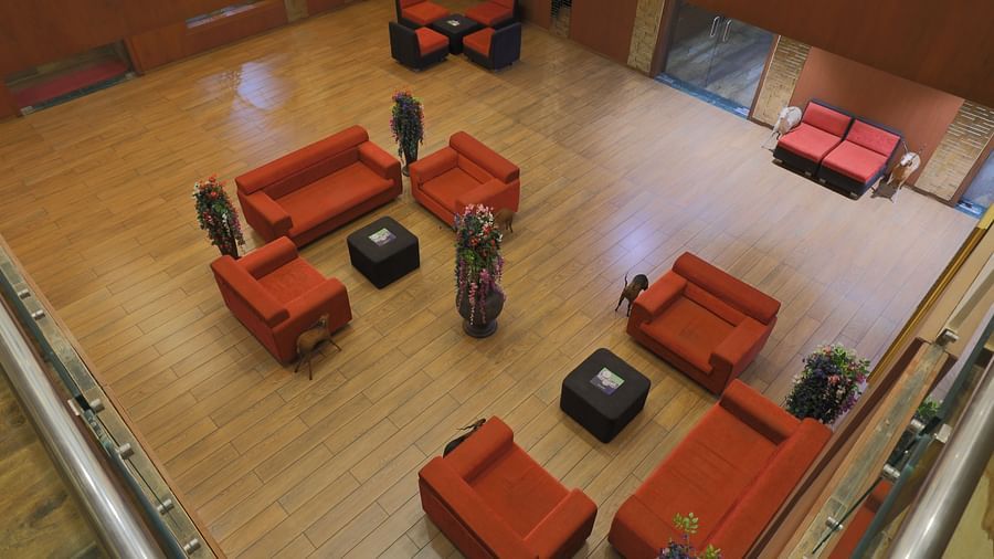 A top angle shot of the lobby at our hotel featuring the common seating area and wooden flooring - Vishal Lords Inn Gir Forest