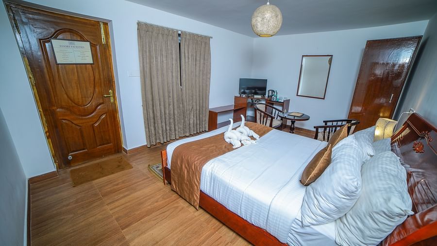 Side view of a room with a bed, a door, and window in front at WOW Bison Woods.
