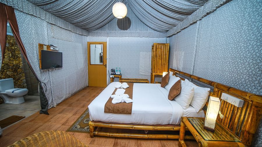 Side view of a room with a bed and a wooden table beside it at WOW Bison Woods.