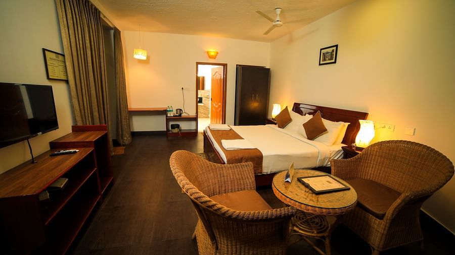 Image of a room with a bed, a television, and a seating area on the side at WOW Bison Woods.