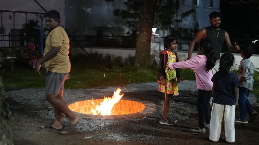 A well-lit bonfire with several guests gathered around it dressed in casuals during an evening at the WOW Naturefull Resorts.