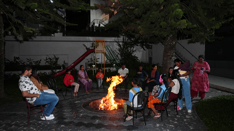 A bonfire set up made in an outdoor space with people enjoying by it. | WOW Naturefull Resorts, Yercaud
