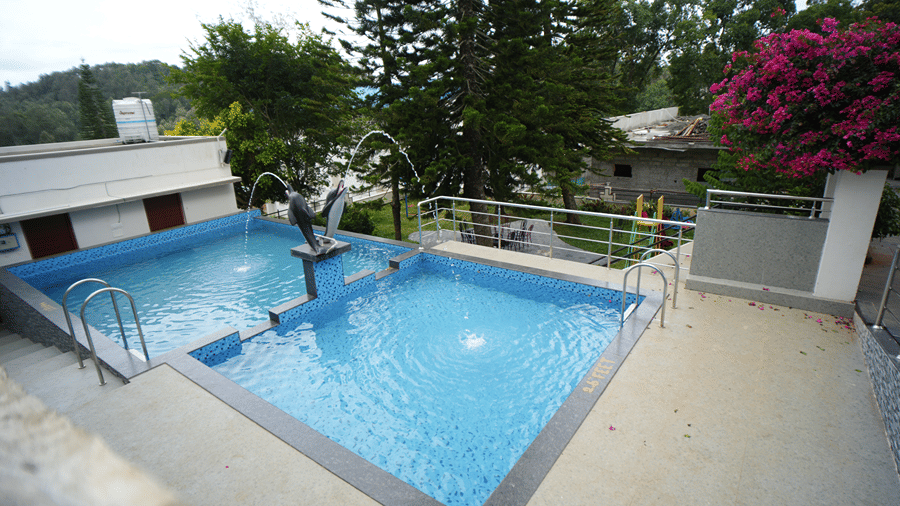 A Swimming Pool with plants and trees by it. | WOW Naturefull Resorts, Yercaud