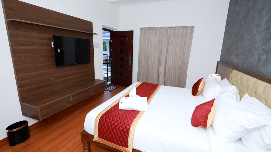 Corner-view shot of the Standard Room with a double bed facing towards a wall-mounted television at WOW Naturefull Resorts, Yercaud.