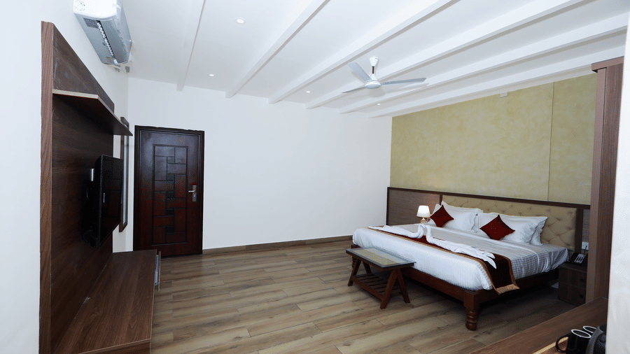 A wide-angle shot of the Nature Luxury Room featuring a well-kept double bed at WOW Naturefull Resorts, Yercaud.