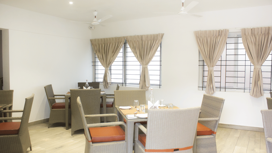 A full-view shot of the Spice and Slice Restaurant with well-arranged dining tables at WOW Naturefull Resorts, Yercaud.