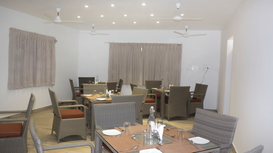 The Spice and Slice Restaurant with dim lighting along with 4 fans hanging from the ceiling at WOW Naturefull Resorts, Yercaud.