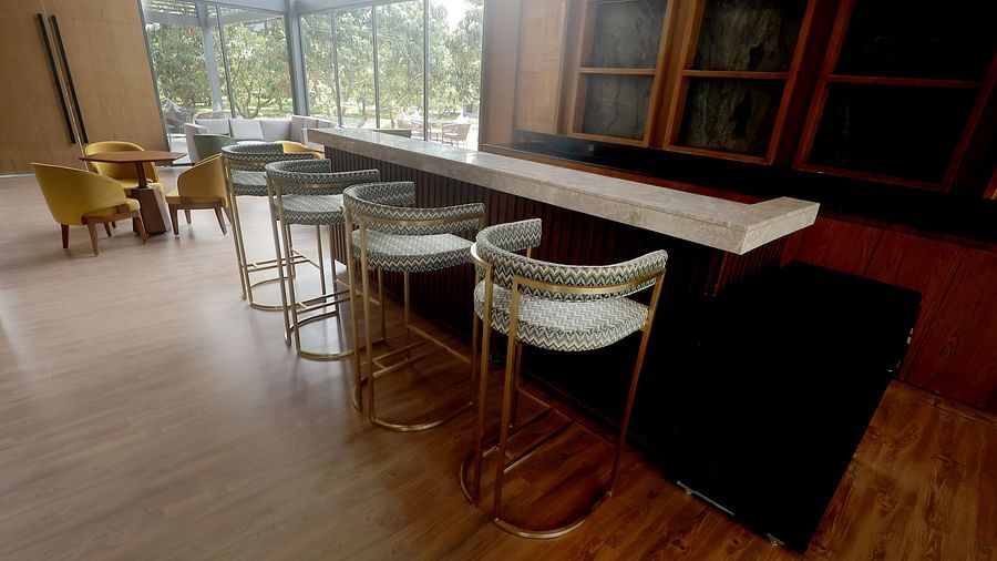 Stylish bar area with high stools and a wood-finished counter set against large windows at Wyndham Garden.
