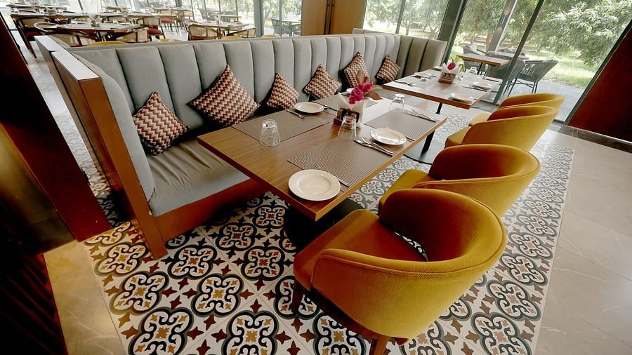 Stylish indoor seating with mustard yellow armchairs, patterned floor tiles, and a plush corner sofa at Wyndham Garden.