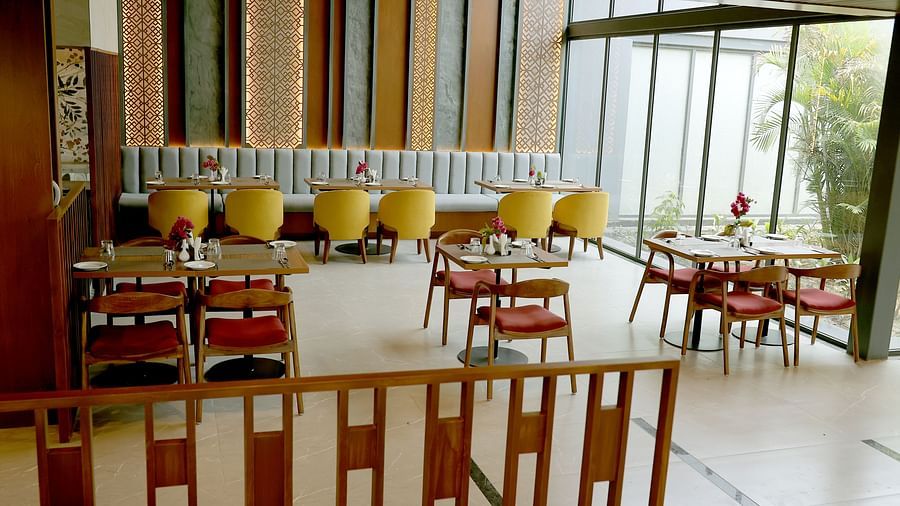 Vibrant indoor restaurant with patterned walls and wooden dining tables at Wyndham Garden.