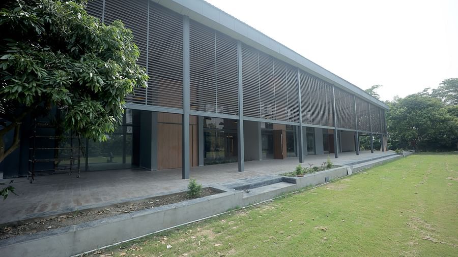 Modern building façade with large glass windows facing a well-kept lawn and trees at Wyndham Garden.