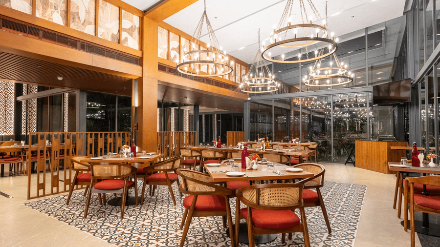 An open and airy restaurant space at Wyndham Garden with elegant seating and high glass walls.