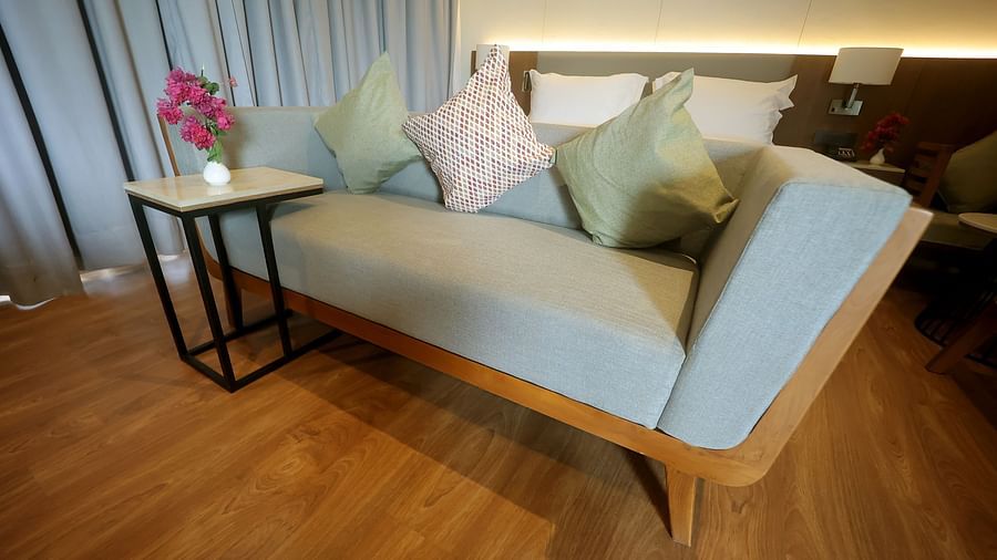 Stylish corner with a powder blue upholstered chaise lounge, cushions, and a side table on wooden flooring at Wyndham Garden.