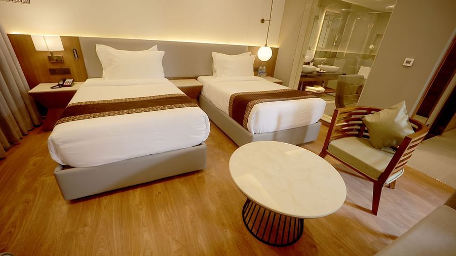Spacious twin room with contemporary furnishings and a round coffee table at Wyndham Garden.