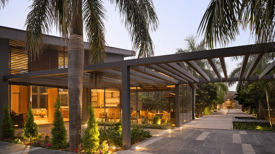 Illuminated hotel entrance with palm trees at dusk at Wyndham Garden.