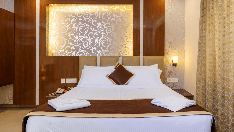 Deluxe room with bed and pillows at Wyt Hotels, Rameswaram
