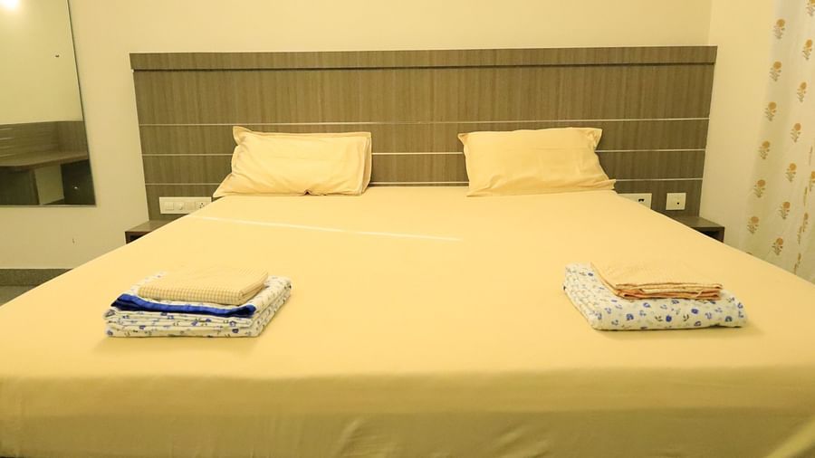 A bedroom with a large bed, pillows, and towels.