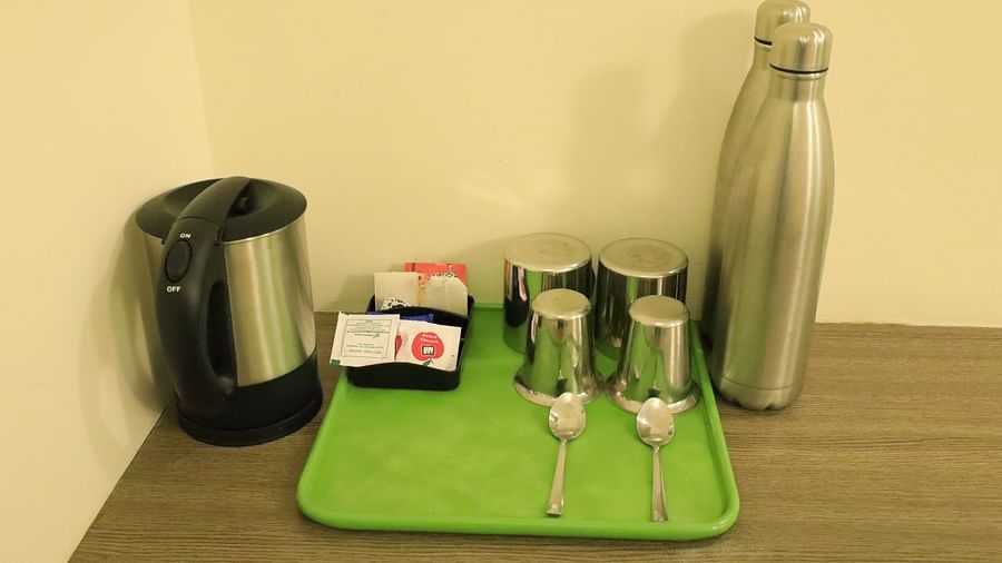 A tray with a kettle, cups, and a water bottle.