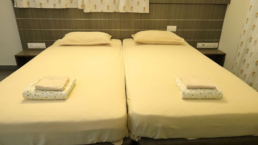 A well-lit bedroom with two beds and nightstands.