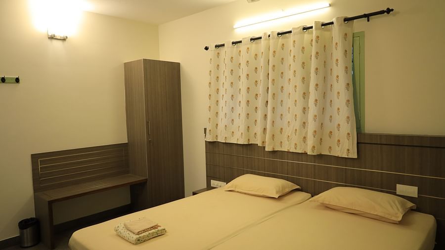 A well-lit bedroom with a double bed, wardrobe and curtains.
