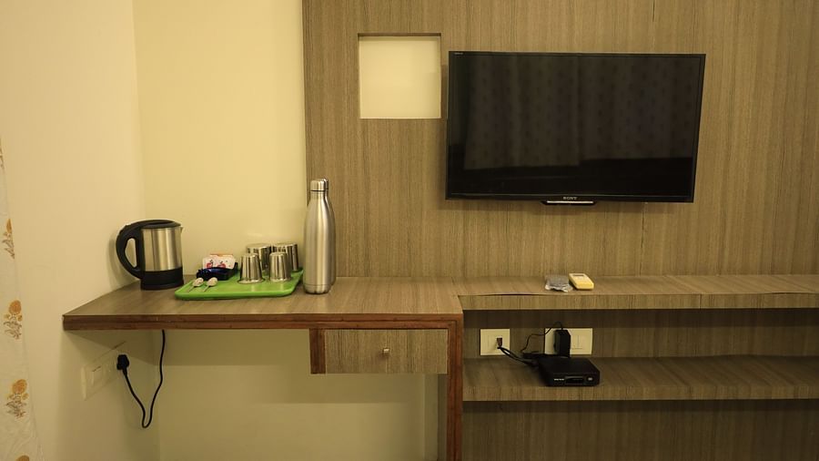 A image of the room with a TV, kettle, and desk.