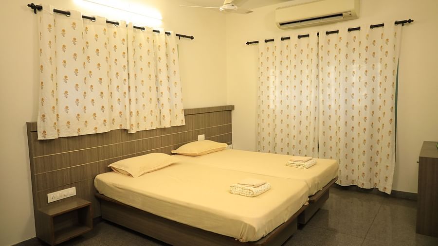 A shot of the bedroom with a bed, nightstands, and curtains.