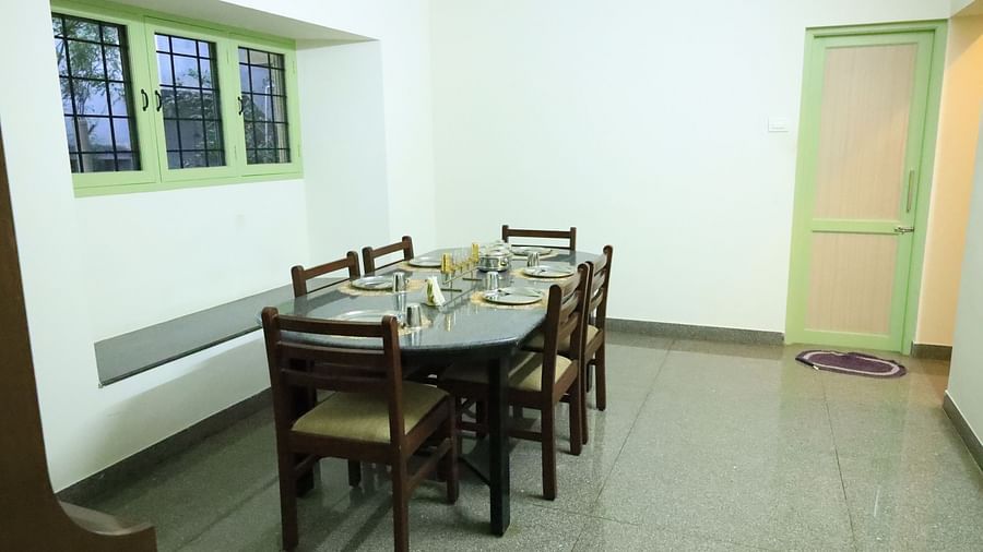 Image of a bright and airy dining room with large windows.