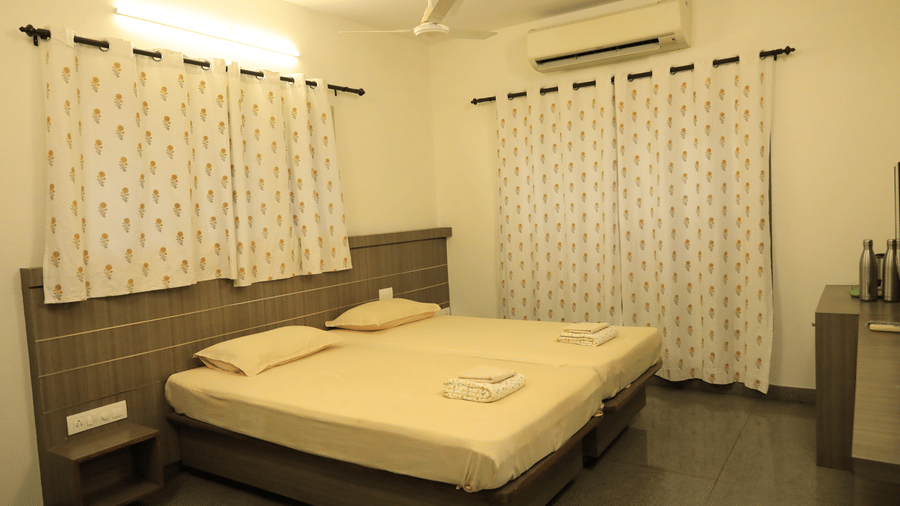 A cosy bedroom at Wyt Hotels Transit Nest, Madurai featuring a comfortable bed and soft pillows.