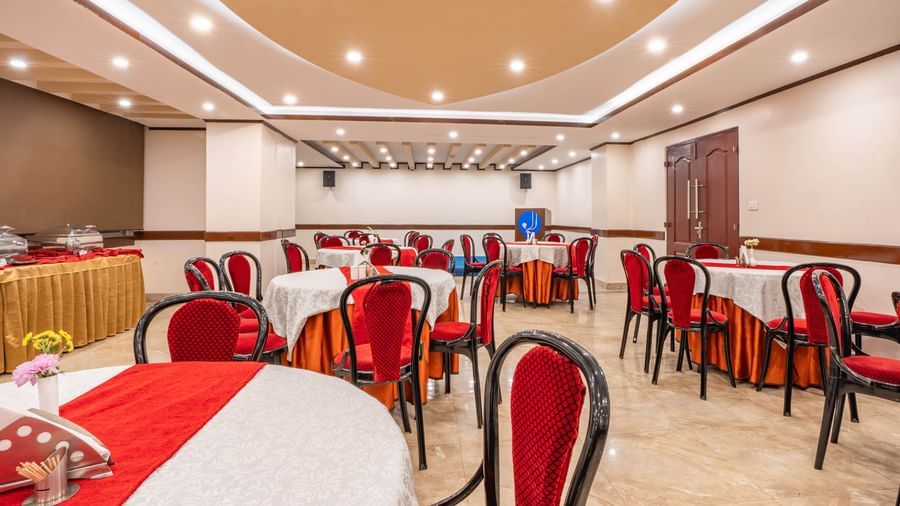 A formal dining setup inside the elegant banquet hall of the Yashshree Jai Hotel & Banquet, Darjeeling.