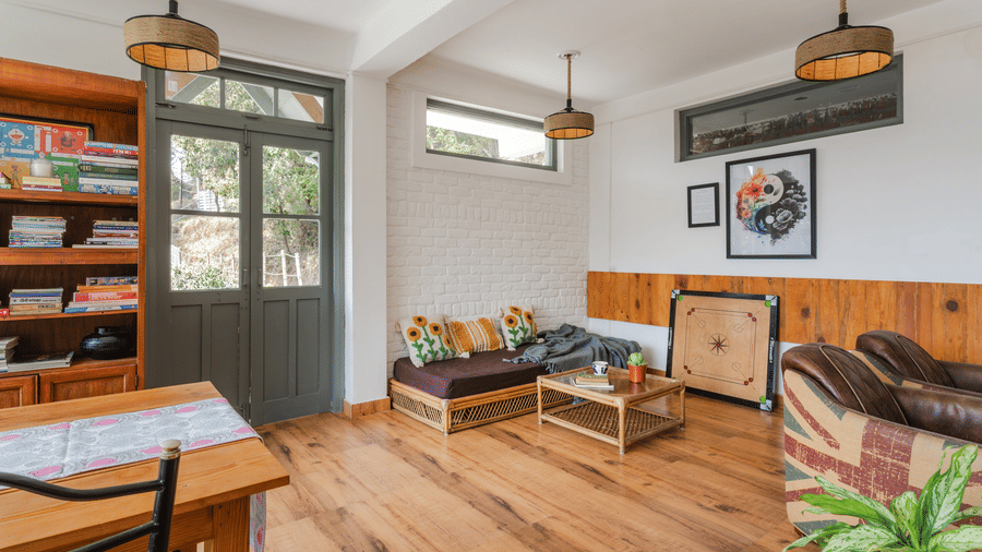 An indoor living and dining area with wooden furniture and a bookshelf at Ziran Retreat.