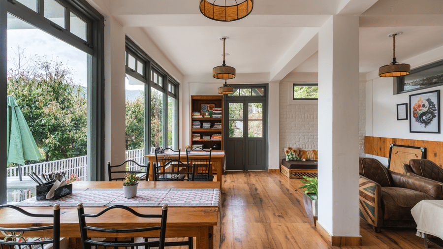 An indoor dining and living area with large windows at Ziran Retreat.