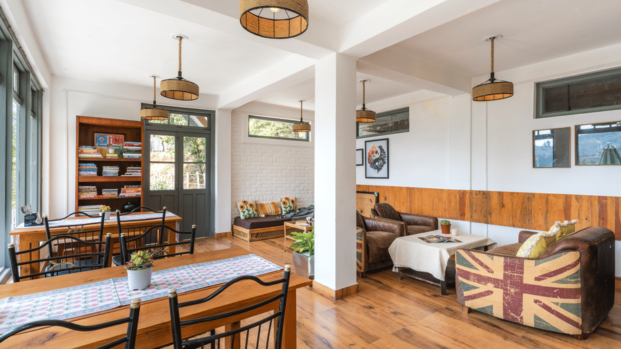 An indoor dining and living area with wooden floors and furniture at Ziran Retreat.