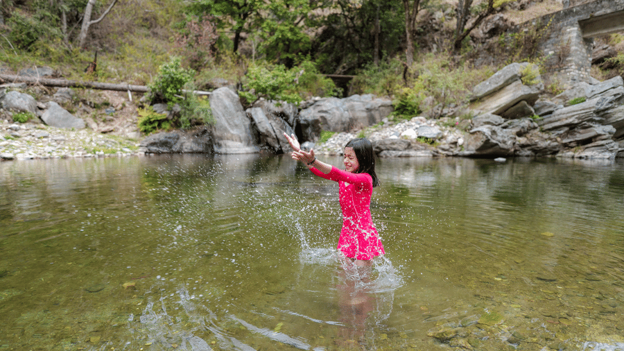 A lady standing in a river near Ziran Retreat.