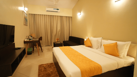 A side wide view of a double bed room with TV, AC and lights