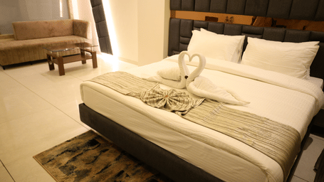 A cosy hotel double bed features beautifully folded swan towels - Lords Inn Sangam, Bhopal